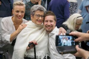 Kolme entistä balettitanssijaa poseeraa ja neljäs henkilö ottaa heistä valokuvaa kännykällään.
